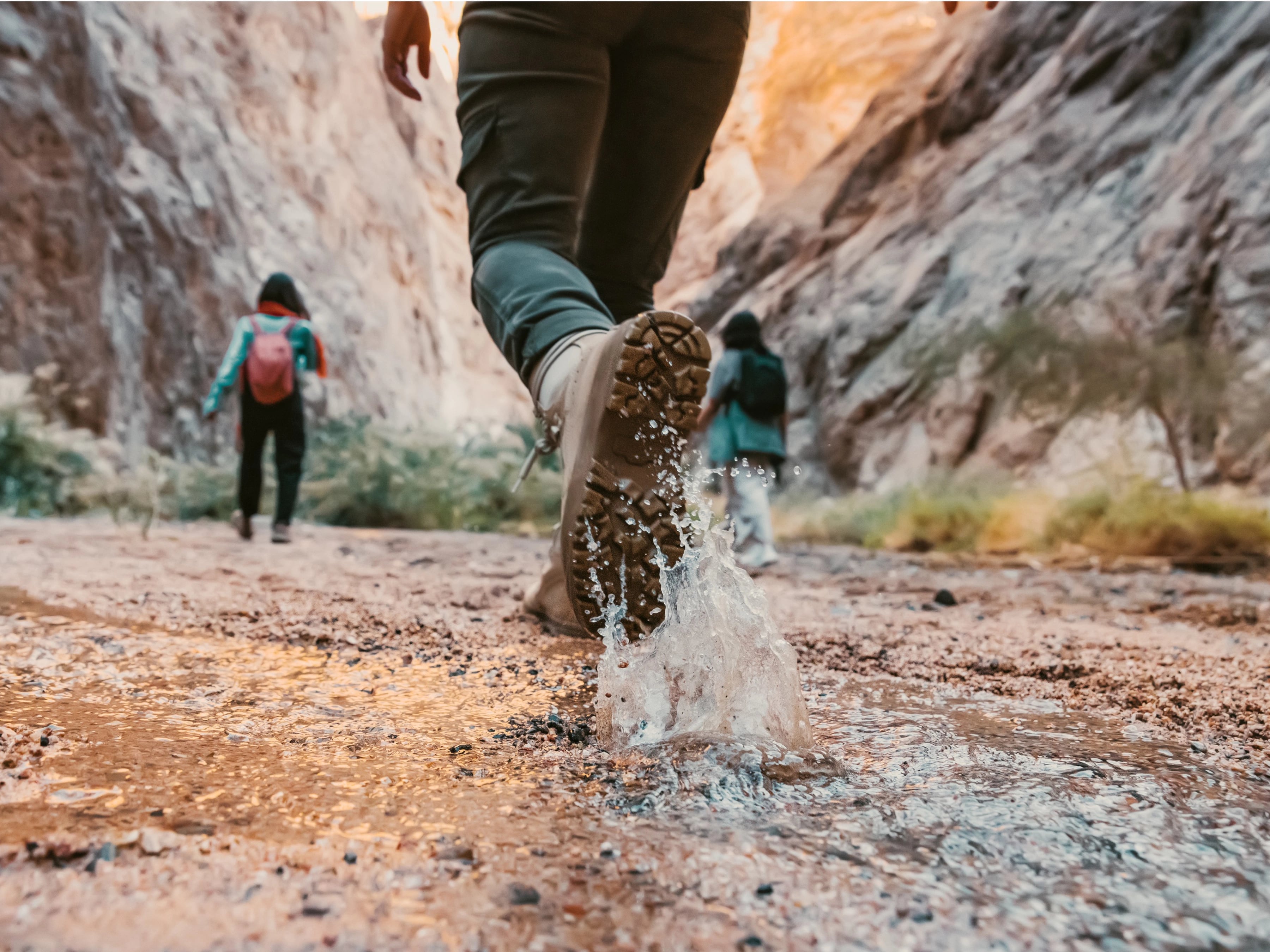 Visitors walking through a canyon